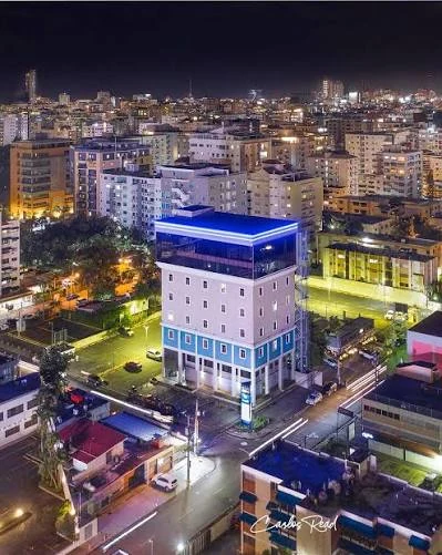 Edificio Mezzo Tempo iluminado de noche, con la ciudad de fondo